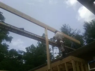 Carpenter setting a ridge beam over a new addition frame — Ice Dam Removal by Roofing Brothers in West Middletown